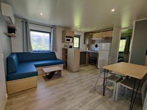 - un salon et une cuisine dans une petite maison dans l'établissement Camping la Haie Penée ****, à Saint-Quentin-en-Tourmont