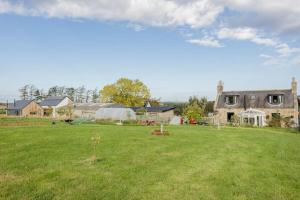 a large yard with a large house and a house at Cosy and modern 1 bedroom garden house - very dog friendly! in Tarves