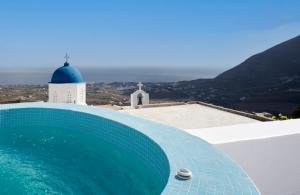 a swimming pool on the roof of a building with a church at Aecon Suites in Éxo Goniá