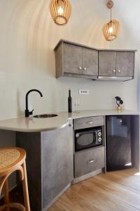 uma cozinha com armários de aço inoxidável e um balcão em Aecon Suites em Éxo Goniá