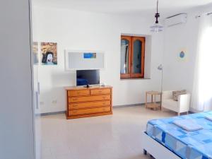 a bedroom with a bed and a dresser in it at Aeolian Apartments in Lipari