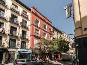 a street with buildings and a car parked in front at El Tesoro de Malasaña in Madrid