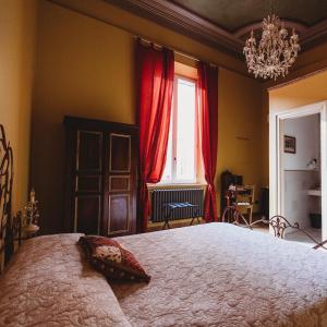 a bedroom with a large bed with red curtains at Salotto delle Arti in Modena