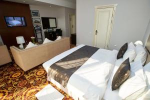 ビシュケクにあるガーデン ホテルのベッドルーム(大型ベッド1台付)、リビングルームが備わります。