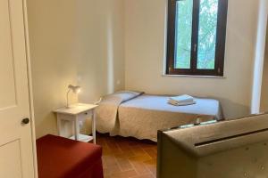 a small bedroom with a bed and a window at Residenza Cipressi e Olivi in Verona