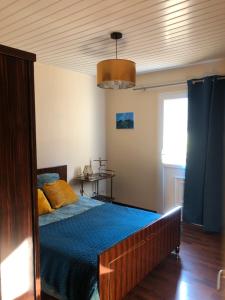 a bedroom with a bed with a blue comforter at Gite de la cascade in Les Planches-près-Arbois