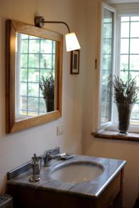 a bathroom with a sink and a mirror and two windows at Agriturismo Tenuta Conti Faina in Fratta Todina