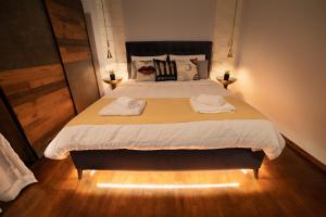a bedroom with a large bed with two towels on it at URBAN MAISON in Larisa