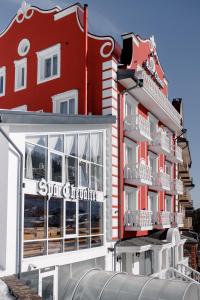 um edifício vermelho com uma placa para um hotel em Chevalier Hotel & SPA em Bukovel