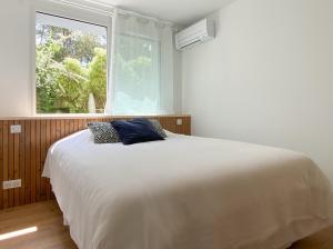 una camera da letto con un grande letto bianco con una finestra di Appartement Océane - Villas Lake and Sea a Seignosse