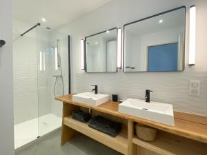 un bagno con due lavandini e una doccia di Appartement Océane - Villas Lake and Sea a Seignosse