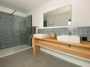 un bagno con due lavandini e uno specchio di Appartement Océane - Villas Lake and Sea a Seignosse Altre 13 foto