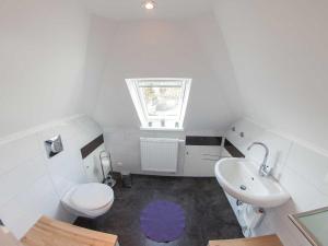 une salle de bain blanche avec toilettes et lavabo dans l'établissement Ferienwohnung Anker, FeWo Vermittlung Nordsee, à Dangast