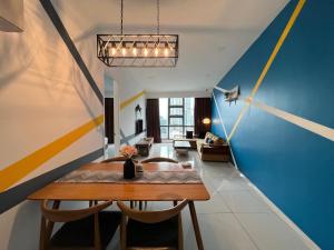 a dining room with a table and a blue and yellow wall at Eclipse Suites Robertson Bukit Bintang in Kuala Lumpur