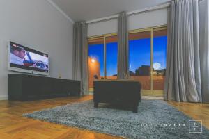 a living room with a flat screen tv and a large window at This is Heaven in Funchal in Funchal
