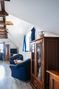 a living room with two blue chairs and a cabinet at Cselling Udvarház in Révfülöp