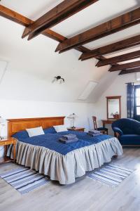 a bedroom with a blue bed in a room with wooden ceilings at Cselling Udvarház in Révfülöp +85 photos
