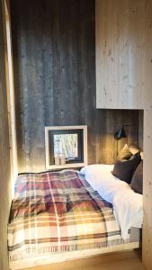 um quarto com uma cama e uma parede de madeira em Fuglekassehytta 
