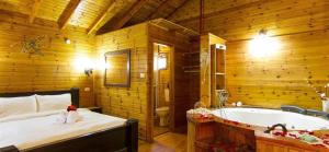a bathroom with a bed and a tub in a room at Keren Or in Netiv HaShayyara +8 photos