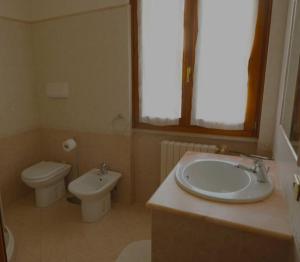 a bathroom with a sink and a toilet at Villa Lidia - tra il verde e l’azzurro. in San Felice del Benaco +4 photos