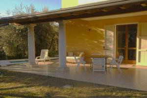 a patio with chairs and a table in front of a house at Villa Lidia - tra il verde e l’azzurro. in San Felice del Benaco