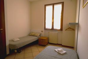 a small room with two beds and a window at Villa Lidia - tra il verde e l’azzurro. in San Felice del Benaco