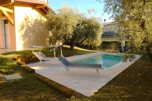 two chairs sitting next to a swimming pool at Villa Lidia - tra il verde e l’azzurro. in San Felice del Benaco