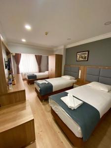 a hotel room with two beds and a television at Kafkas Hotel Istanbul in Istanbul