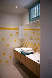 a yellow and white bathroom with a sink and a window at Les Pamplemousses charmante villa proche de la mer in Porquerolles
