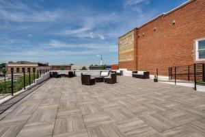 eine Terrasse mit Sofas und Stühlen auf einem Gebäude in der Unterkunft The Davis Lofts at Main Street - Unit 3D in Rocky Mount