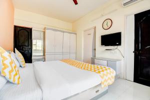 a bedroom with a white bed and a tv at FabHotel Corporate Residency in Pune