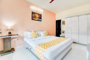 a bedroom with a large bed with orange walls at FabHotel Corporate Residency in Pune