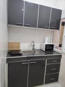a kitchen with a sink and a microwave at F2 Appart Les Ambassades Point E, Dakar in Dakar