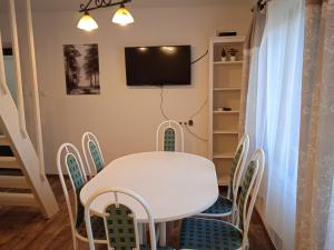 a dining room with a white table and chairs at Kispatak Erdei Ház in Kismaros