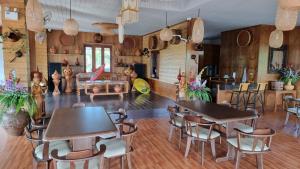 un comedor con mesas y sillas y una sala con en Butsaba Garden Resort, en San Pāyang