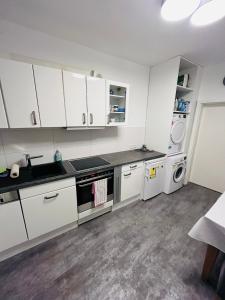 a kitchen with white cabinets and white appliances at B&O Vermietung in Kerken