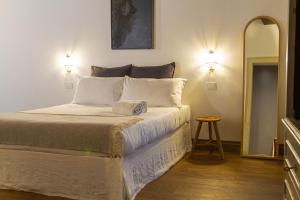 1 dormitorio con cama con almohadas blancas y espejo en Palazzo Glori 6 en Cremona