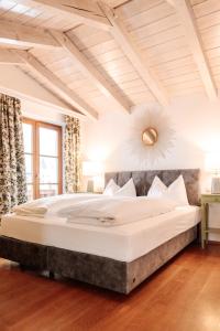 a large white bed in a bedroom with a ceiling at Hubertus Boutiquehotel Filzmoos in Filzmoos