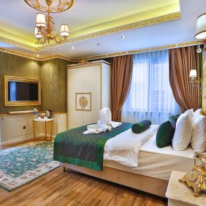een slaapkamer met een groot bed en een televisie bij Emirhan Palace Hotel in Istanbul