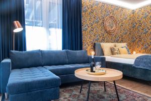 a living room with a blue couch and a table at Grand Suites Corvin in Budapest
