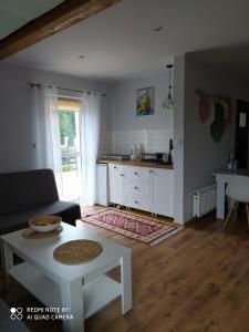 a living room with a table and a kitchen at Apartament Radochów 138G in Lądek-Zdrój
