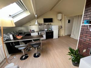 a kitchen with a counter and chairs in a room at Duplex Cosy et Familial in Fontenay-sous-Bois