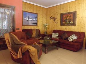 Sala de estar con 2 sofás y mesa en CASA RURAL EL ESCUDERO, en El Toboso
