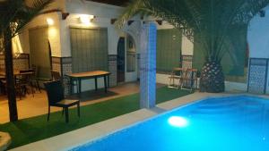 a swimming pool with a table and chairs and a table and a table at CASA RURAL EL ESCUDERO in El Toboso