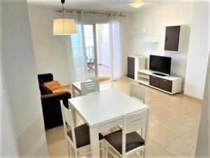 a living room with a white table and a television at Apartamento Grao de Moncofar REF. 041 in Moncófar