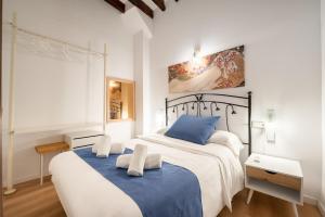 two beds in a bedroom with white and blue at Holiday Palma Apartments - TI in Palma de Mallorca