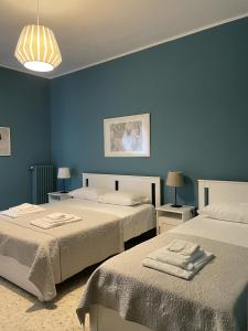 1 dormitorio con 2 camas y pared azul en Interno2 Bari Centrale en Bari