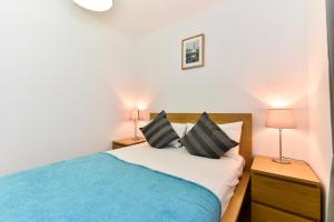 a bedroom with a bed and two night stands and two lamps at London City Lofts in London