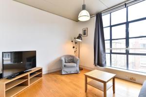 a living room with a couch and a tv at London City Lofts in London