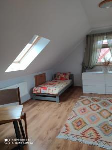 a attic room with a bed and a table at Apartament Radochów 138G in Lądek-Zdrój